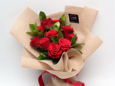 Red roses bouquet in natural burlap wrap with red ribbon