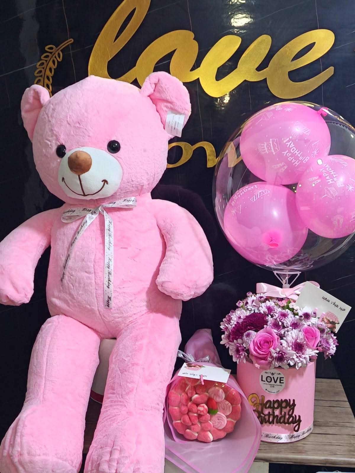Pink teddy bear birthday gift set with flowers and balloons